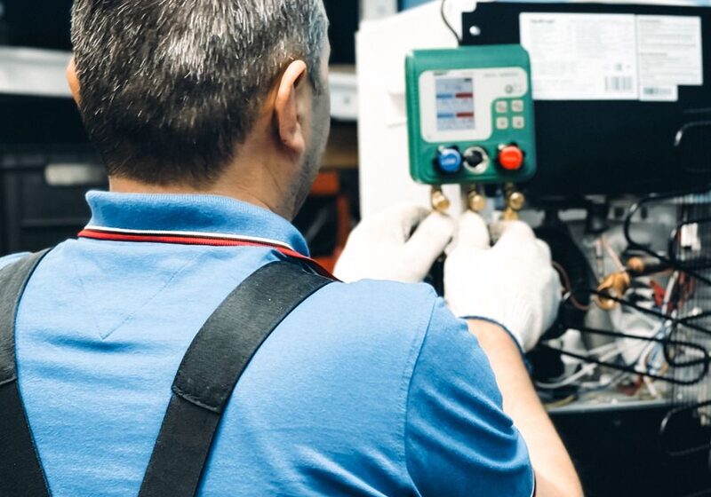 Technician servicing indoor heating equipment with gauges